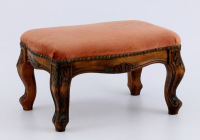 Lote 5149 - BANQUETA DE PÉS – Formato rectangular em madeira de mogno entalhada, circa 1920-30, tampo estofado a veludo de tom rosa velho, com pregaria. Dim: 24x41x28 cm. Nota: sinais de uso