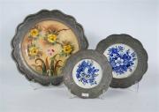 Lote 20 - Lote de 3 pratos em porcelana pintada à mão com motivos florais, bordo em estanho trabalhado, com diâmetros entre 19 e 31 cm Nota: usado