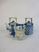 Lote 23 - Lote composto por 3 bules miniatura em cerâmica oriental, decoração a azul e branco, com medidas entre 9 cm e 12 cm de altura