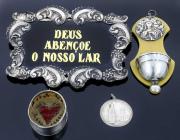 Lote 24 - CONJUNTO RELIGIOSO EM PRATA 833 - Composto por pequena pia de agua benta de parede com reservatório e medalhão, pendente, pequeno registo de pendurar e moldura com inscrição em vidro ao centro "Deus Abençoe o Nosso Lar". Peso aproximado da Prata: 50 g. Dim: 18x14 cm (aprox. Moldura). Nota: sinais de uso e armazenamento. Falhas e defeitos. Marcas de contraste em vigor de 1938 a 1984 e sem marcas de contraste ao abrigo do Decreto-Lei n.º 120/2017