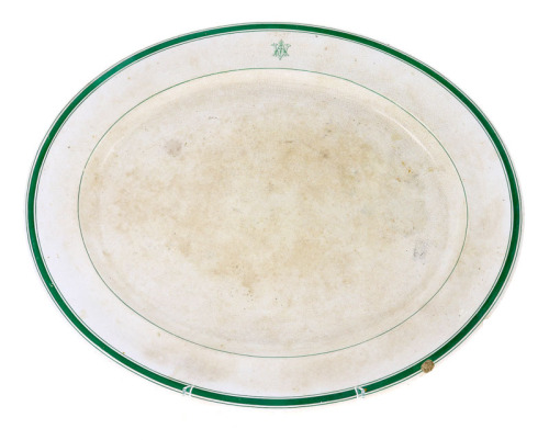 Lote 135 - TRAVESSA GRANDE EM FAIANÇA - Decoração com filetes e monograma a verde. Marcas no tardoz a carimbo e por impressão na pasta (ambas ilegíveis). Dim: 54,5x46,5 cm. Nota: sinais de uso. Esbeiçadelas, craquelé e manchas