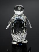 Lote 111 - SWAROVSKI - Escultura em cristal austríaco representando Pinguim. Decoração facetada com relevos. Punção oficial marcada na base. Alt. aprox. : 8.5cm.
