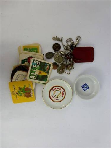 Lote 31 - Lote composto por 2 cinzeiros de porcelana e faiança com inscrições e medidas de 12,5 cm e 10 cm de diâmetro, 23 bases de cartão com publicidade diversa, com 9x9 cm e 13 porta chaves diversos de metal prateado e dourado, com medidas entre 7 cm 