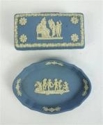 Lote 89 - Conjunto de caixa guarda-jóias e aneleira em porcelana inglesa Wedgwood, em tom azul com decoração clássica a branco, caixa com 3x9x5 cm e aneleira com 8x11cm
