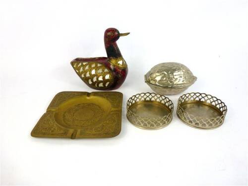 Lote 118 - Lote de 5 peças , tais como diversas tais como pato decorativo de madeira com aplicações de latão e madrepérola, com 15x15 cm , base para garrafas em metal, quebra-noz com formato de noz e cinzeiro em latão cinzelado, com 16x16 cm Nota: peças u