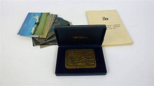 Lote 190 - Lote composto por medalha de bronze da TAP, com dedicatória, em estojo, com 7x9 cm, 35 postais com imagens de aviões e livro de abreviaturas, siglas e simbolos usados em aviação comercial, da TAP Air Portugal