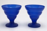 Lote 216 - TAÇAS - duas taças em vidro azul, de corpo cónico gomado e pé alto, para gelado. Dimensão: 12x11,5ø cm. Pequenas marcas de uso