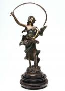 Lote 4019 - ESTATUETA EM BRONZE - Estatueta de estilo Arte Nova em bronze esmaltado (múltiplo), motivo Bailarina, com vestido esmaltado de verde, não assinada, sobre base de mármore e base amovível de madeira. Dimensão: 45 cm de altura (sem base de madeira).