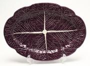 Lote 4152 - BORDALLO PINHEIRO - travessa em faiança Bordallo Pinheiro vidrada a roxo, ornamentada com folha de couve, marcada na base. Dimensão: 37x26 cm. Bom estado geral