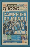 Lote 59 - O JOGO "CAMPEÕES DO MUNDO" - Poster da 1ª Página "O Jogo", de 2004.12.13, com fotografia da equipa vencedora. Dim: mancha 57x36 cm. Dim: moldura 63x42 cm