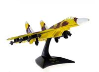 Lote 62 - MAISTO, SUKHOI SU-37 – Modelo miniatura de avião caça. Miniatura à escala não inscrita. Em metal castanho e amarelo camuflado, com componentes em plástico. Suporte de exposição em plástico preto com referências. Made in China. Dim: 12,5 cm de co