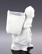Lote 170 - PALITEIRO EM BISCUIT - Decoração de menina com cesto em vulto perfeito. Dim: 10,5 cm (altura). Nota: falhas e defeitos, cesto partido e colado
