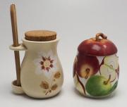 Lote 10 - POTES - dois potes para cozinha em faiança, pote ornamentado com maçãs e pote com tampa em cortiça e com pinça em madeira pintado à mão com flor. Dimensão: 18,5 cm e 26,5 cm de altura. Bom estado geral