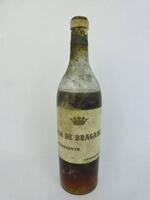 Lote 953 - Lote de 1 garrafa de Aguardente CASA DE BRAGANÇA 1940(data escrita à mão), Vendas Novas. Vinho muito raro, com valor de venda aproximado de 100€. Nota: com perda.