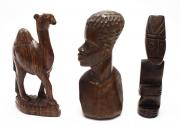 Lote 4059 - ARTE AFRICANA - três esculturas esculpidas à mão em madeira exótica africana, um busto masculino africano, com 21x9x6 cm, uma escultura masculina sentada, com 20x4,5x4,5 cm, e escultura de dromedário, com 21x5,5x13 cm. Bom estado geral