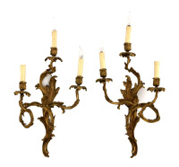 Lote 5102 - APLIQUES DE PAREDE EM BRONZE - Par de apliques electrificados de 3 lumes cada em bronze dourado. Conjunto idêntico vendido numa leiloeira de Lisboa por € 1300. Decoração relevada com flores e enrolamentos vegetalistas, estilo Luís XV. Lumes co