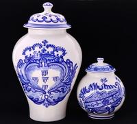 Lote 5271 - POTES DE FARMÁCIA EM PORCELANA PORTUGUESA - Conjunto de 2 potes com tampa em porcelana, decorações de corpo bojudo com pintura feita à mão em tons de azul. Dim: 16 e 30 cm (altura). Marcadas no base Viana do Castelo. Nota: sinais de uso