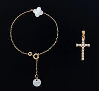 Lote 5504 - PULSEIRA E CRUZ PENDENTE EM OURO - Conjunto de pulseira em malha de elos com e pendentes em madre pérola e cruz cravejada com pérolas. Peso total: 2,7 g. Dim: 16,5 cm (pulseira) e 28 mm (cruz). Nota: sinais de uso, cruz com marcas