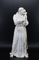 Lote 5735 - SANTO ANTÓNIO COM MENINO - Escultura de Santo António com menino em gesso. Santo António com vestes relevadas com aurela sobre a cabeça e cinto em corda. Assinado Leonel, e datado anos 70. Dim: 29 cm (altura). Nota: com cabelos. Possivelmente 