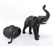 Lote 6 - ARTE TRIBAL AFRICANA, ELEFANTES - Conjunto de figura de elefante em pele e cabeça de elefante em madeira exótica. Dim: 30x27x10 cm e 20x200x9 cm respectivamente. Nota: bem conservados