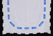 Lote 65 - TOALHA DE LINHO COM BORDADOS - Toalha de mesa em tecido de linho branco, bordada à mão com flores em linha branca, com aplicações de tecido azul, remate dentado a ponto cheio. Dim: 85x86 cm. Nota: sinais de uso