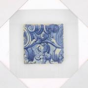 Lote 25 - AZULEJO, SÉC. XVIII - Azulejo antigo aplicado em moldura vitrine (branca). Decoração em tons de azul, pintado à mão, com motivos vegetalistas. Dim: 14x14 cm (azulejo), 29,5x29,5 cm (moldura). Nota: sinais de manuseamento