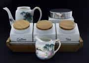 Lote 97 - POTES DE COZINHA, BULE E LEITEIRA EM PORCELANA - Conjunto de 4 peças em porcelana, composto por base de madeira com 3 potes para café, açucar e chá, pote em porcelana branca com tampa de metal, bule e leiteira em porcelana oriental. Dim: 10x30x12 cm (suporte com potes). Nota: sinais de uso, bule sem tampa