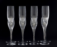 Lote 5057 - ATLANTIS, COPOS DE PÉ ALTO EM CRISTAL - Conjunto de 12 flutes e 11 copos de licor, decoração lapidado, marca gravada na base. Dim: 24,5 cm e 17 cm de altura. Nota: sinais de uso