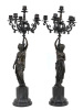 Lote 5279 - PAR DE CANDELABROS DE SEIS LUMES - Em metal relevado e vazado com motivos vegetalistas, fustes em bronze patinado representando figuras femininas relevadas, assentes sobre plintos com bases circulares em mármore preto. Dim: 73 cm (altura total