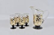Lote 8 - Lote de 1 jarro e quatro copos de refresco em vidro, com decoração vegetalista dourada e base preta. Dim: 23X13cm; 15X6,7cm.