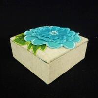 Lote 215 - Caixa pequena em tecido com 10x10x5 cm com flor azul