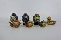 Lote 41 - Colecção de 7 peças miniatura em cloisonné composto por 3 bules com base em madeira com 4 cm, 3 potes com decoração floral sendo 2 com fundo azul e 1 com fundo cor de tijolo, com 5 cm e caixa em forma de pato com 5x7 cm