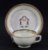 Lote 18 - CHÁVENA DE CHÁ COM PIRES ARMOREADOS EM PORCELANA DA CHINA SÉC. XVIII/XIX - Período Jiaqing (1796-1820). Chávena e pires com decoração a azul e dourado e escudo encimado por timbre de família europeia. Dim: 5x8,5 cm (chávena) e 14 cm (pires). No - 2