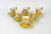 Lote 173 - Conjunto de 6 chávenas e respectivos pratos de porcelana Kahla made in GDR, decoradas em tons de amarelo com medalhões de flores e dourados, com 7x6 cm e 11 cm de diâmetro, Nota: usado (1 chávena com pequena esbeiçadela na base)