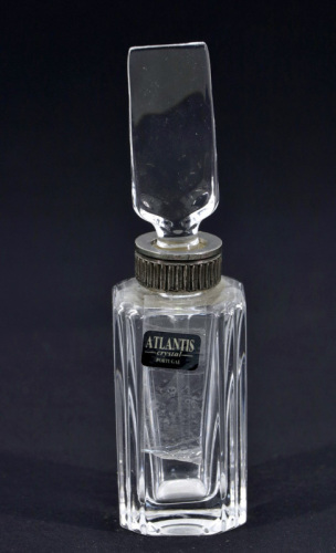 Lote 37 - ATLANTIS, FRASCO DE PERFUME - Em cristal lapidado. Tampa com palheta em cristal. Bordo com aplicação em metal relevado. Dim. 12 cm. Nota: marcado na base