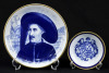 Lote 144 - SPAL, PRATO E COVILHETE - Conjunto de 2 peças em porcelana marcada na base, composto por prato com decoração alusiva ao "Infante D. Henrique" e covilhete decorado com as "Armas atribuídas a Matias de Albuquerque", decoração em azul com frisos d