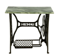 Lote 101 - SINGER, MESA DE MÁQUINA DE COSTURA - Estrutura em ferro com decoração vazada e logotipos da marca com pedal. Adaptada a mesa de apoio com tampo em resina verde simulando mármore. Dim: 79x74x40 cm