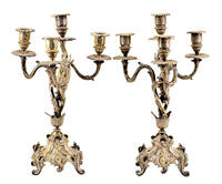 Lote 79 - CANDELABROS EM CASQUINHA, Séc. XIX/XX - Par de candelabros de 4 lume profusamente decorados em relevo ao estilo D. João V com volutas, e elementos vegetalistas relevados. Assente em 4 pés trabalhados. Dim: 37 cm. Nota: sinais de uso