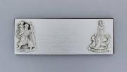 Lote 992 - Placa em prata com figuras em baixo relevo com 26,12 gramas de peso total, e 88 X 32 mm ( comp. X larg.); base de madeira