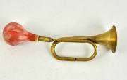 Lote 2196 - Instrumento de sopro em metal amarelo e borracha antiga, c/ sinais de uso. Compº 38cm.