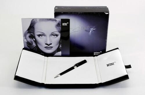 Lote 3 - MONTBLANC, ESFEROGRÁFICA - Modelo Marlene Dietrich. Corpo em resina preta com aros e clip em plaqué de platina. Clip cravejado com safira e topo com aplicação em madrepérola envolvendo o logotipo da marca. Esferográfica idêntica à venda por € 755