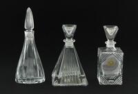 Lote 317 - FRASCOS PARA PERFUME EM CRISTAL - Conjunto de 3 frascos com formatos e decorações lapidadas diversas. Dim: 17 cm (maior)