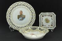 Lote 318 - CONJUNTO DIVERSO EM PORCELANA - Composto de 3 peças sendo 1 prato com decoração policromada e dourada com o busto do Rei Jorge V e bordo vazado, 1 prato fundo Artibus com decoração floral e bordo vazado e 1 covilhete em porcelana alemão com dec