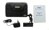 Lote 552 - SEGA MASTER SYSTEM II, CONSOLA DE JOGOS - Model Nº: 3006-18. Consola icónica dos anos 1990s com o respectivo comando, transformador e manual de instruções. Dim: 7x26x18 cm. Nota: testada, a funcionar correctamente. Consola muito procurada e va