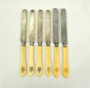 Lote 21 - Conjunto de 6 facas de sobremesa com cabos em osso decorados com monograma gravado, 2 lâminas com marca da ManufRe. de Coutellerie A.Transon. Paris e 4 com lâminas cinzeladas, antigos, sinais de uso
