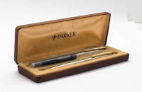 Lote 10 - PARKER - caneta de aparo e esferográfica da marca Parker, modelo 45, made in England, com corpo prateado em aço escovado com detalhes a dourado, vintage, em estojo, com recarga. Dimensão: 13 cm e 14 cm. Bom estado