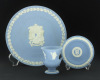 Lote 592 - WEDGWOOD, PRATO, JARRA E COVILHETE EM PORCELANA INGLESA - Conjunto de 3 peças marcadas na base, em porcelana azul com decoração relevada a branco, composto por prato de Natal, jarra e covilhete. Dim: 22 cm (prato)