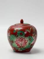 Lote 19 - POTE, MACAU - pote com tampa em porcelana de Macau com corpo bojudo pintado à mão com motivos florais poçicromados sobre fundo vermelho de fer, marcado na base. Dimensão: 19x16,5ø cm. Bom estado geral