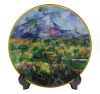 Lote 176 - COLECÇÕES PHILAE, PRATO EM PORCELANA - Prato da colecção O Museu de Porcelana do Impressionismo. Prato com uma reprodução de obra de Paul Cézanne, "A montanha Sainte-Victoire". Dim: 20 cm de diâmetro. Proveniente de colecção particular. Nota: N