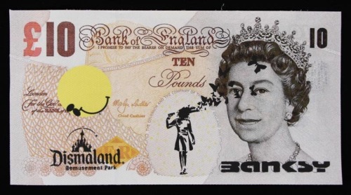 Lote 239 - BANKSY (AFTER) - Impressão sobre tela com assinatura, Edição Dismaland August/September 2015, título "Dismal 10 Pound". Verso com inscrição. Dim: mancha 11x21 cm. Sem moldura. Nota: Banksy (n.1974) é um artista britânico de rua, cujos trabalhos